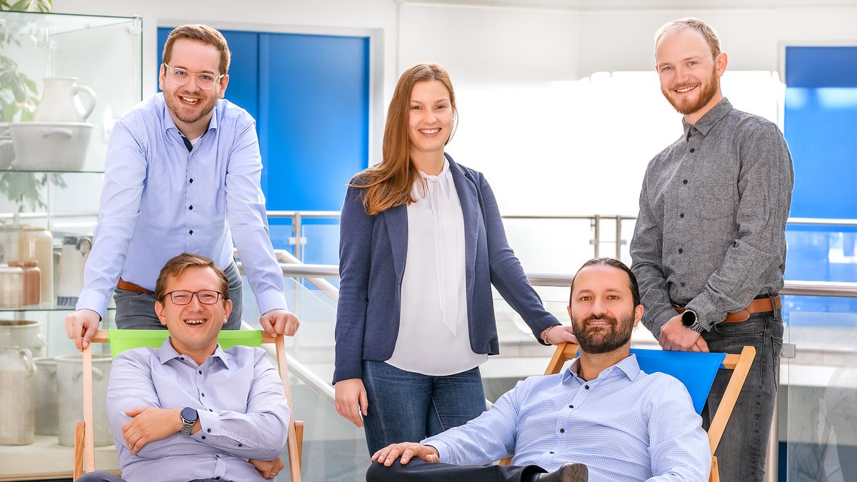 Teamfoto von Hilgenberg-Ceramics: Mitarbeiterinnen und Mitarbeiter in einem hellen Foyer mit Keramikvitrine
